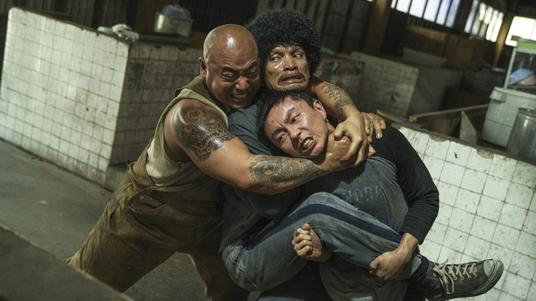 Xie Miao as Wang Wei being held in a headlock in The Furious