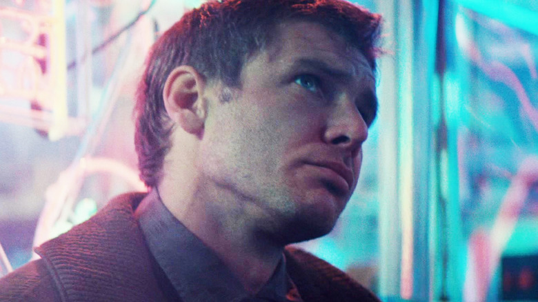 Harrison Ford's Rick Deckard sits in front of neon lights in Blade Runner.jpg