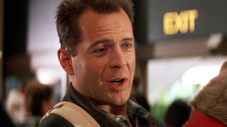 Bruce Willis's John McClane is seen in closeup standing in an airport in Die Hard
