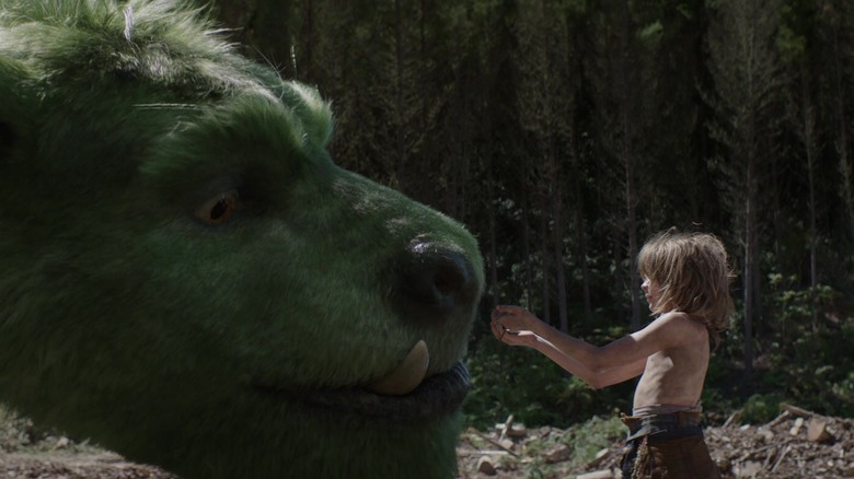 Pete cupping some water in his hands to give to Elliott in Pete's Dragon (2016)