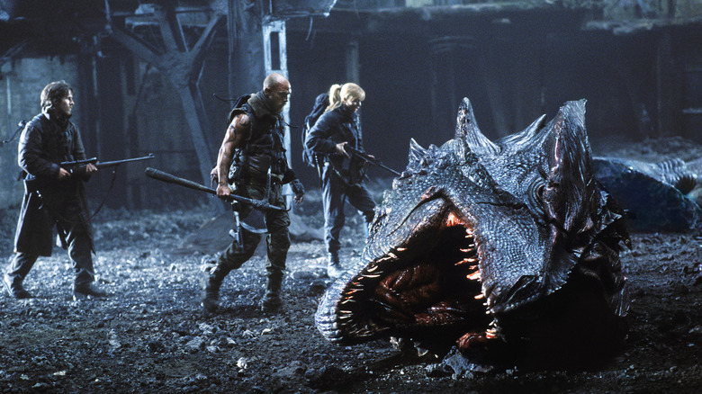 Christian Bale as Quinn, Matthew McConaughey as Van Zan, and Izabella Scorupco as Alex looking at a dragon's head in Reign of Fire