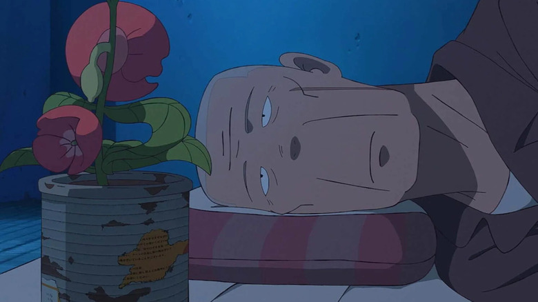 Akutsu in prison looking at a flower in The Last Blossom
