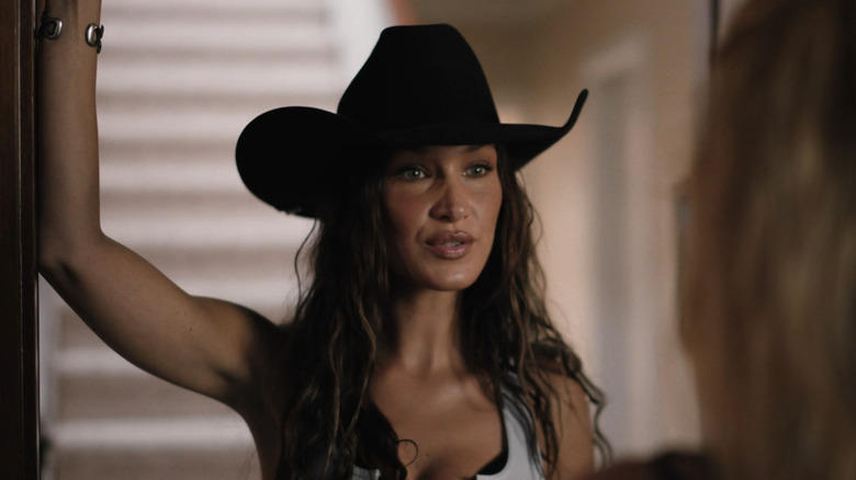 Bella Hadid's Sadie stands in a doorway looking at Kelly Reilly's Beth Dutton in Yellowstone