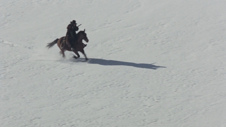 Jean-Louis Trintignant's Silence rides across a snow covered field in The Great Silence