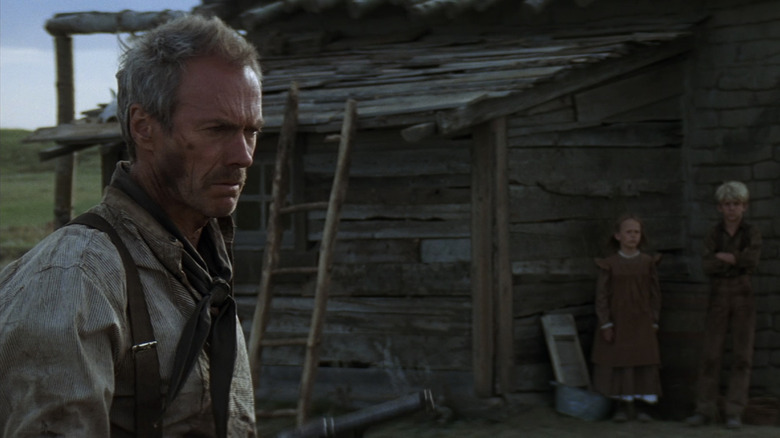 Clint Eastwood's William Munny looks pensive as he stands outside his shack in Unforgiven