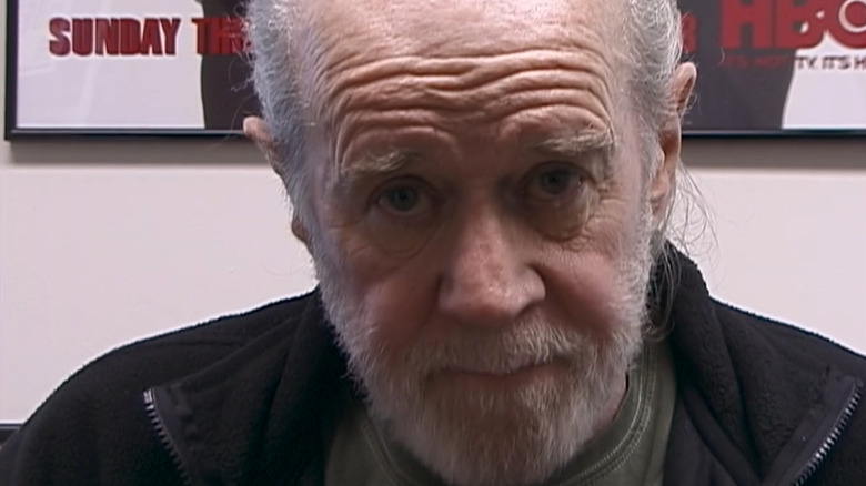 George Carlin staring straight into the camera with a faux-plaintive look in The Aristocrats