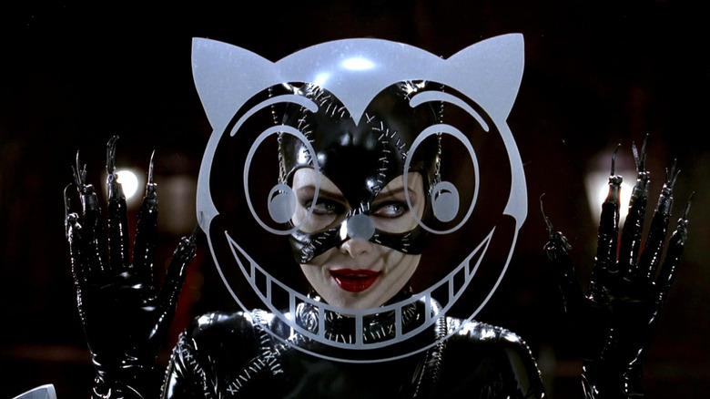 Catwoman smiling behind cat image painted onto window in Batman Returns