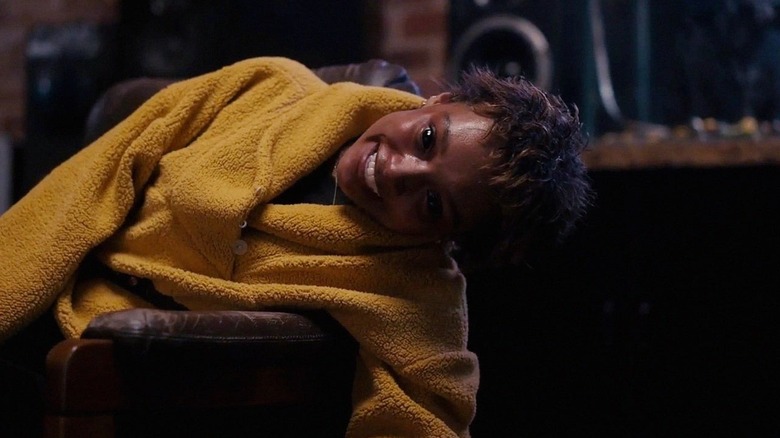 Mia lying down with eerie smile in Talk To Me
