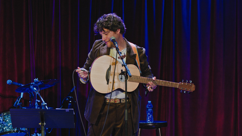 Adam Pally plugging in a guitar in An Intimate Evening with Adam Pally