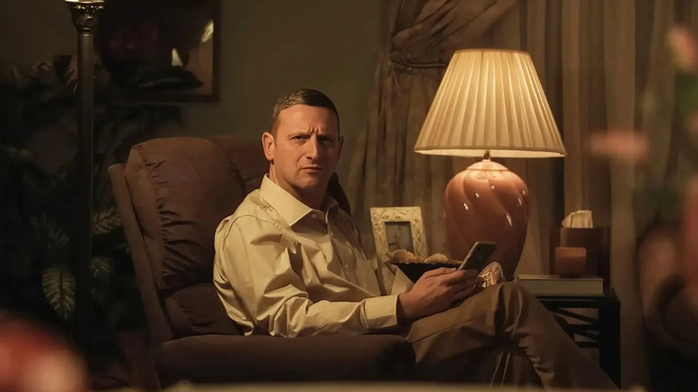 Craig sitting in his chair looking confused and holding his phone in Friendship