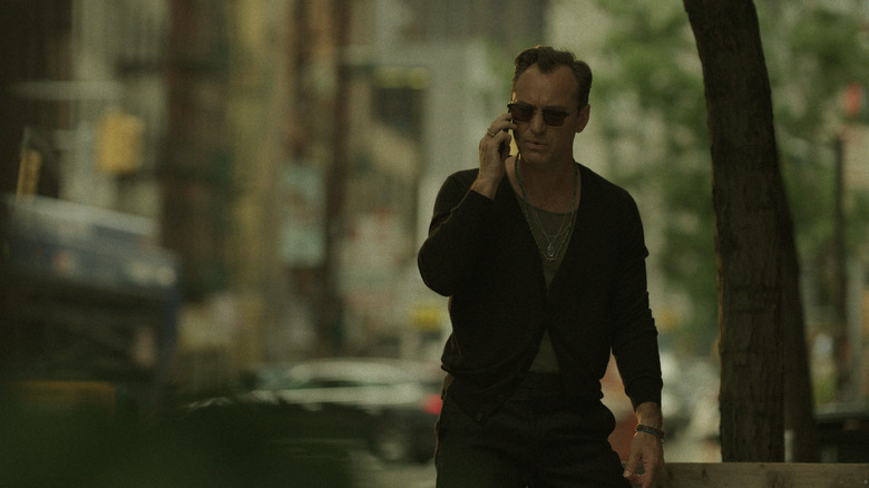 Jake wearing sunglasses walking down the street in Black Rabbit