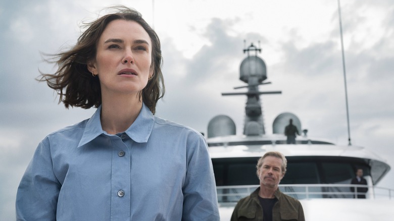 Lo standing at the front of the ship with Richard Bullmer behind her in The Woman in Cabin 10