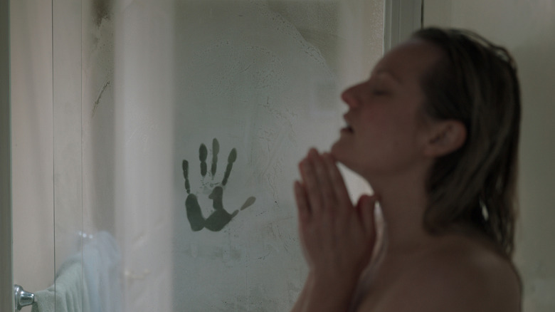 Cecilia in the shower with a handprint on the steamy door in The Invisible Man