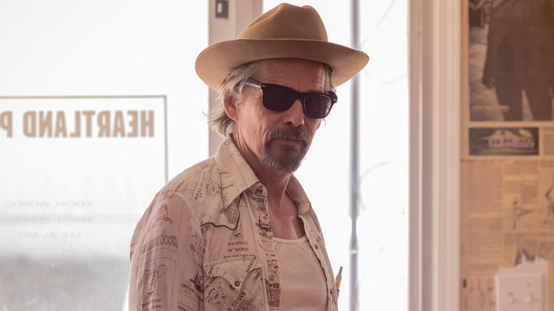 Lee wearing sunglasses and a fedora but managing to look extremely cool anyway in The Lowdown