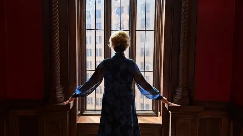 Constance standing in front of a window gazing out in American Horror Story 13