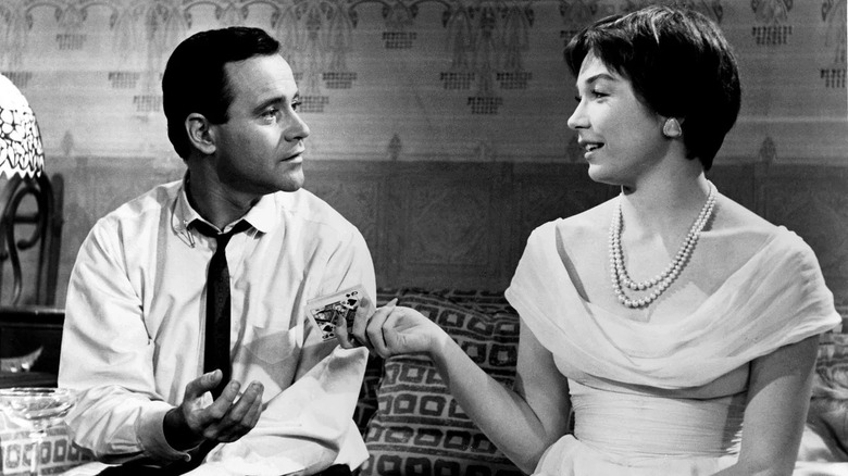 Bud taking cards from Fran on the couch in The Apartment