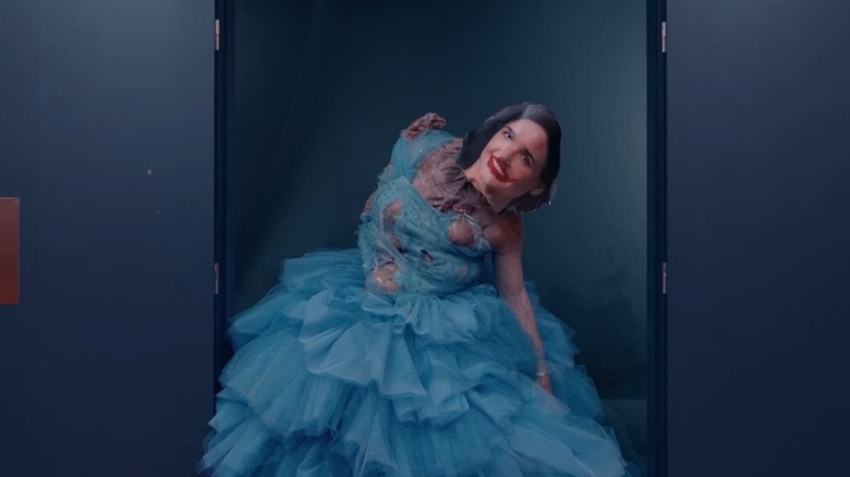 Monstro Elisasue wearing an Elisabeth mask in a gown in The Substance