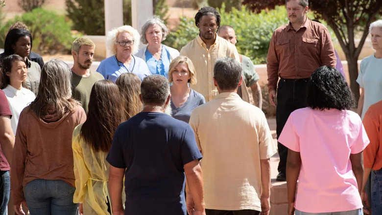 Rhea Seehorn's Carol Sturka surrounded by members of the hive mind on Pluribus