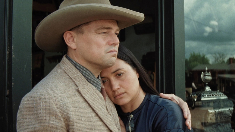 Ernest (Leonardo DiCaprio) frowning while holding his arm around Mollie (Lily Gladstone) in Killers of the Flower Moon