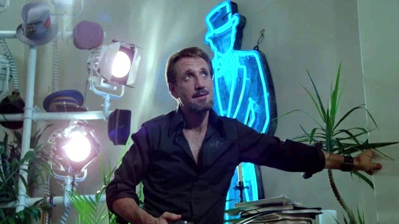 Joe Gideon behind studio lights and neon standee in All That Jazz
