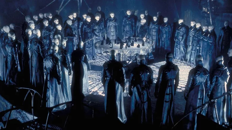 The Strangers gathered around a table in Dark City
