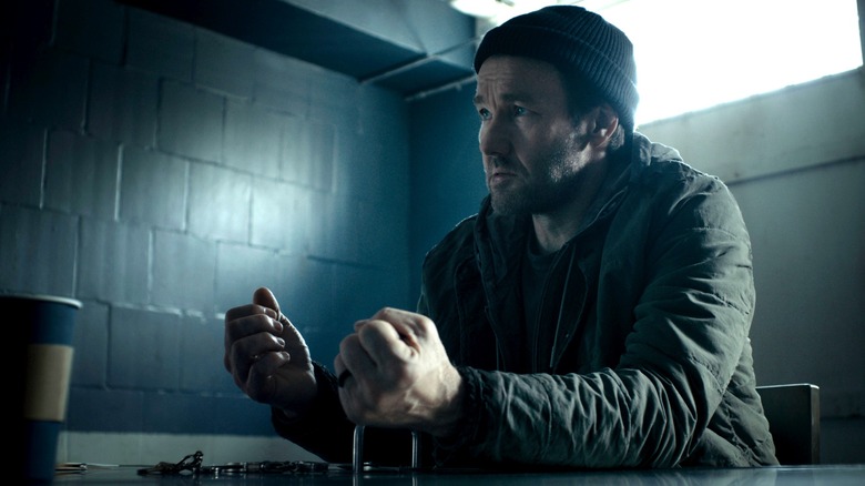 Joel Edgerton as Jason Dessen sitting in an interrogation room with his hands handcuffed to the table in Dark Matter