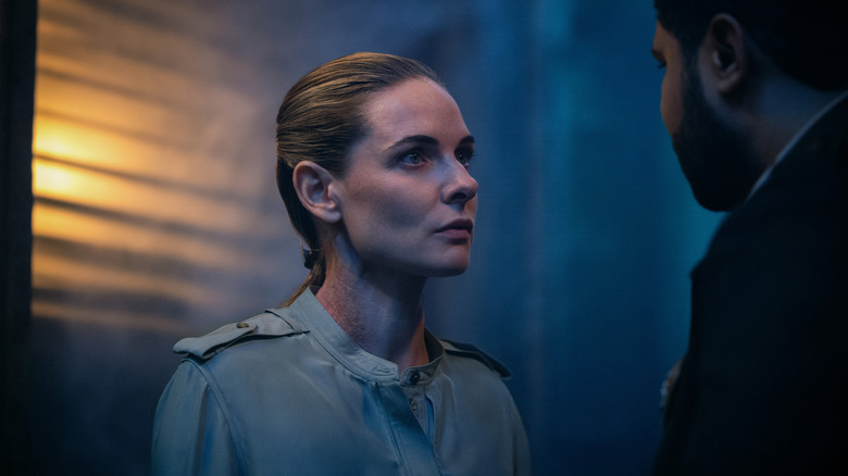 Rebecca Ferguson as Juliette Nichols standing opposite Chinaza Uche as Paul Billings in a hallway in Silo