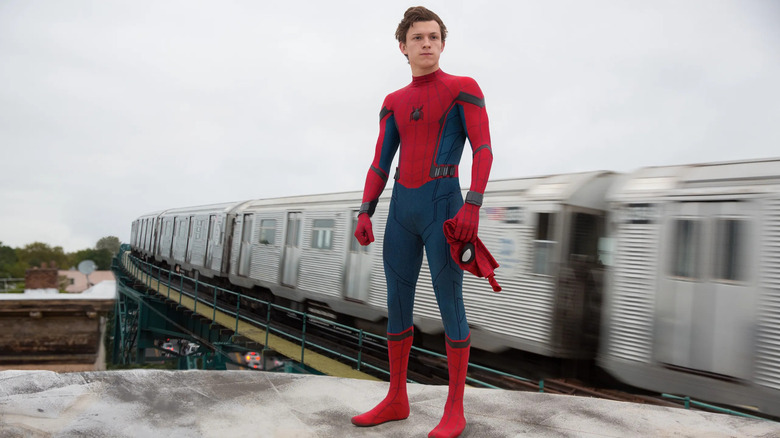 Peter standing near a subway train holding his mask in Spider-Man: Homecoming