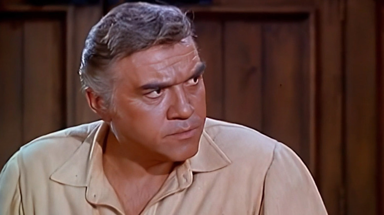 Lorne Greene's Ben Cartwright looks off angrily to his left in Bonanza