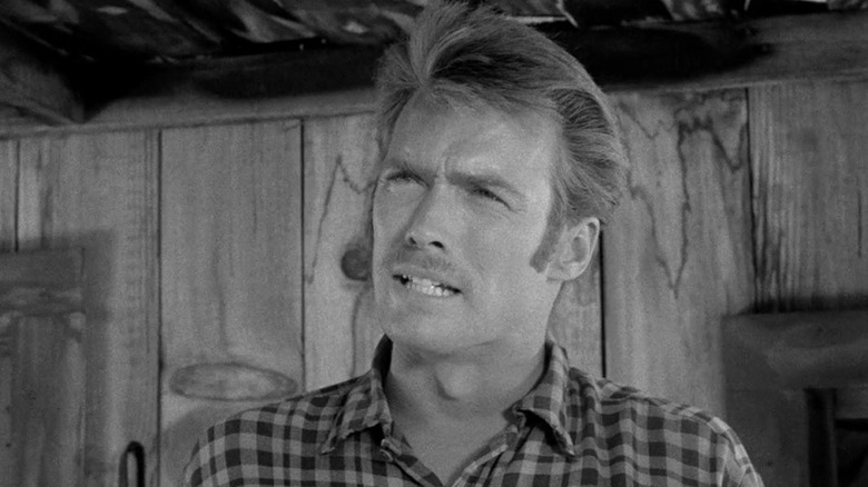 Clint Eastwood's John Lucas looks across frame as he stands on a porch in Death Valley Days