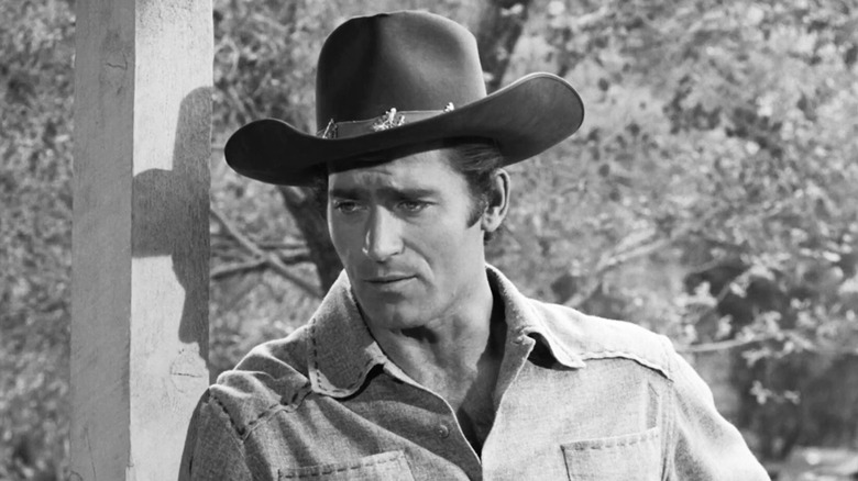 Clint Walker's Cheyenne Bodie leans against a wooden post in Cheyenne