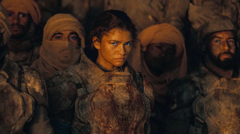 Chani with blue eyes standing in front of a group of Fremen in Dune: Part Two