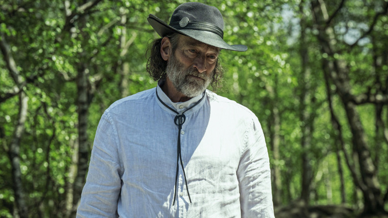 The First Speaker wearing a hat in the woods in Foundation