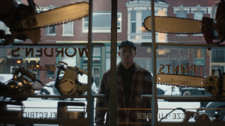 Ed Gein looking at chainsaws in a shop window on Monster: The Ed Gein Story