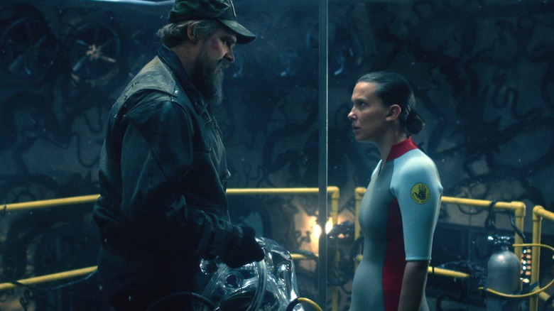 David Harbour's Jim Hopper stands facing Milly Bobby Brown's Eleven by a water tank in Stranger Things