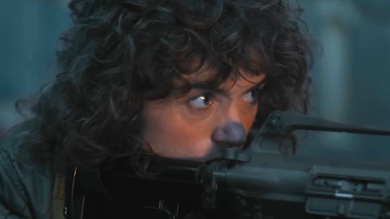 Nancy Wheeler (Natalia Dyer) aiming a gun in Stranger Things