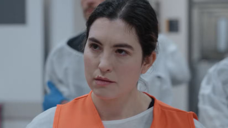 Dr. Emery Walsh in an orange vest scowling on The Pitt