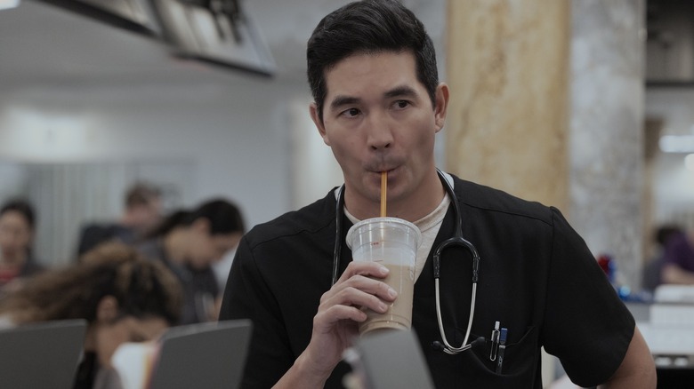 Shen drinking from an iced coffee cup on The Pitt