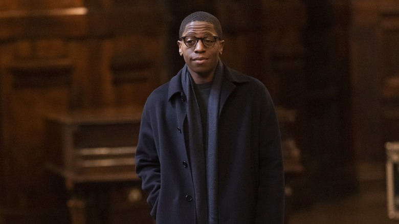 Gus in a navy blue jacket and glasses looking skeptical on Industry