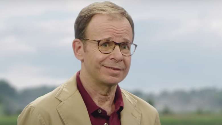 Rick Moranis for Mint Mobile, smiling with raised eyebrows
