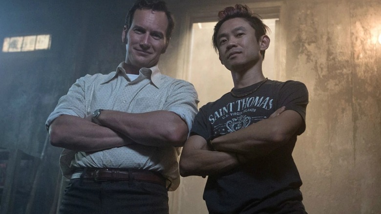 Director James Wan standing next to Patrick Wilson as Ed Warren in a behind-the-scenes still from the set of The Conjuring 2