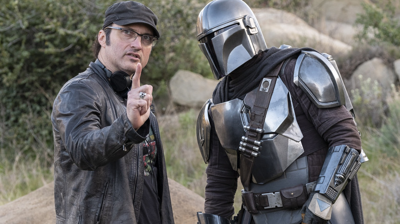 Director Robert Rodriguez standing next to Pedro Pascal as Din Djarin in full armor on the set of The Mandalorian