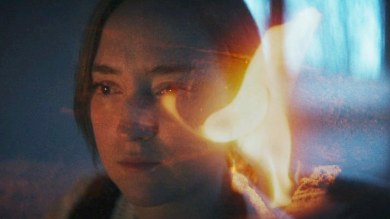 Rachel Stanley looks reflective in closeup with fire superimposed over her face in Spermworld