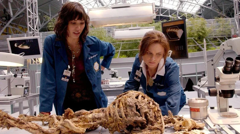 Michaela Conlin as Angela Montenegro and Emily Deschanel as Temperance Brennan investigating human remains on Bones