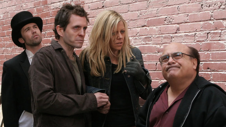Rob McElhenney as Mac, Glenn Howerton as Dennis, Kaitlin Olson as Dee, and Danny DeVito as Frank outside on It's Always Sunny in Philadelphia