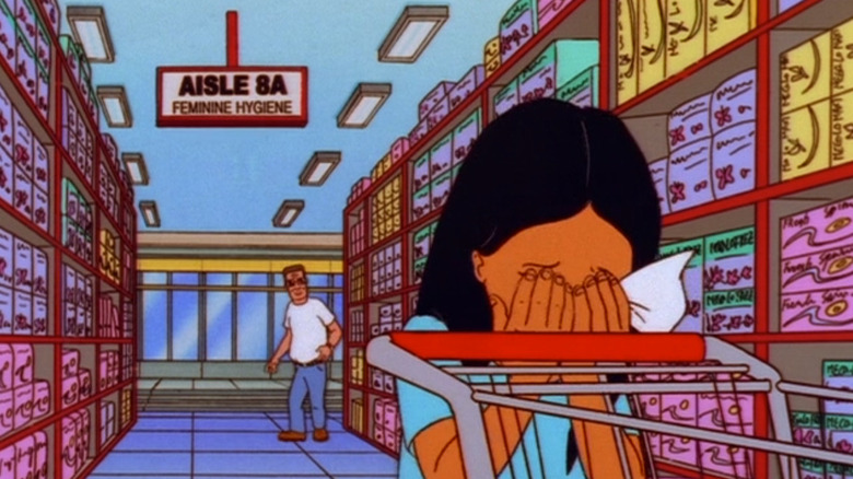 Hank Hill standing at the back of the feminine hygiene aisle while Connie cries in the middle