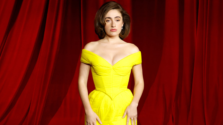 Rachel Sennott posing in front of red curtain