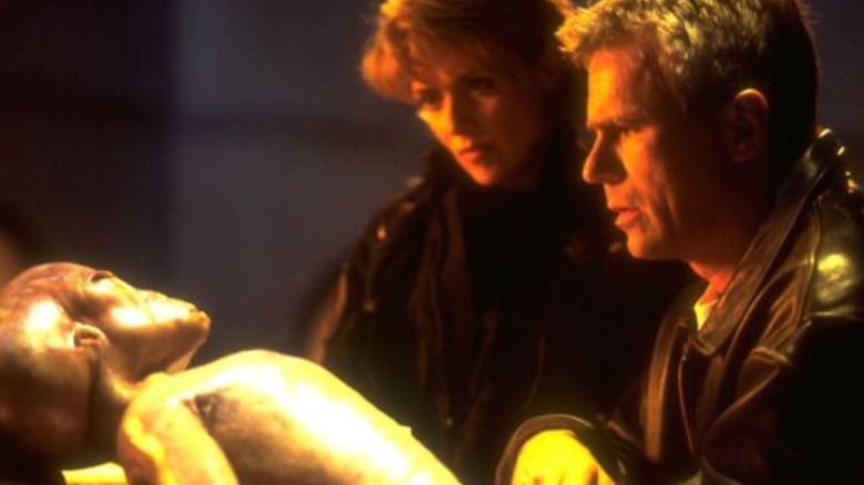 Amanda Tapping's Samantha Carter and Richard Dean Anderson's Jack O'Neill looking at Michael Shanks' Thor on Stargate SG-1