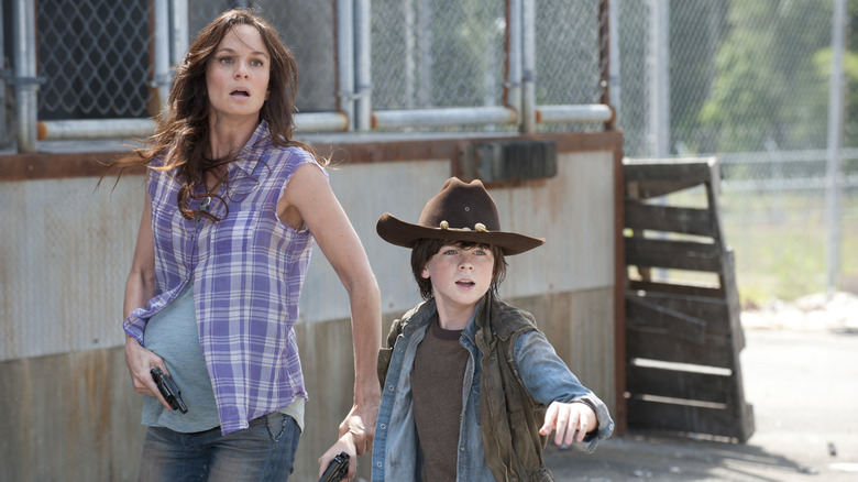 The Walking Dead, pregnant Lori and Carl during a walker ambush, both guns in hand
