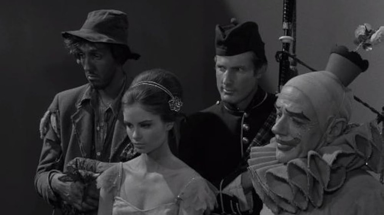 Four of five mismatched characters huddling in the pit in The Twilight Zone